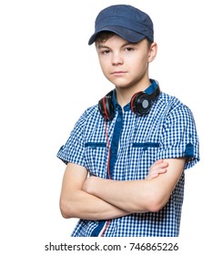 Smiling Teen Boy 14-16 Year Old Posing At Studio. Half-length Emotional Portrait Of Caucasian Guy With Headphones And Cap. Funny Teenager With Arms Folded, Isolated On White Background. 