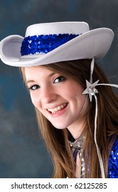 Smiling Teen Cheerleader Wearing White And Blue Hat.