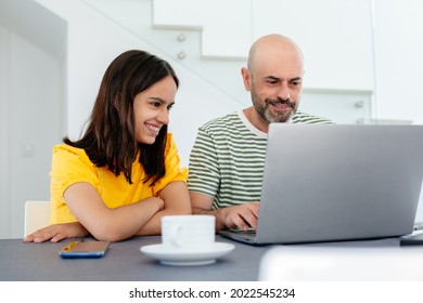 Smiling Teen Girl With Braces Looking At Her Father Working From Home In The Laptop. Focus On Her