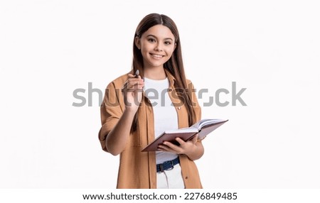smiling teen girl noting school diary in studio. teen girl noting school diary book.