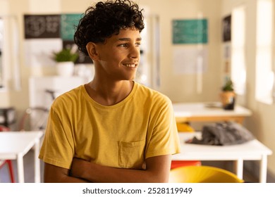 Smiling teenage boy in high school classroom, looking out window during break time. Education, student, youth, happiness, thinking, learning - Powered by Shutterstock