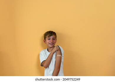 Smiling Teenage Boy Shows A Band Aid On His Arm. Vaccine Concept