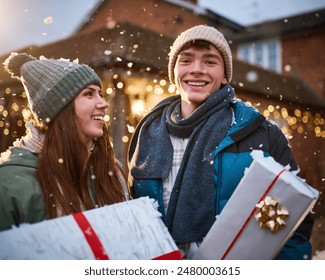 Smiling Teenage Couple Outdoors Dressed For Winter In Snow Delivering Christmas Presents - Powered by Shutterstock