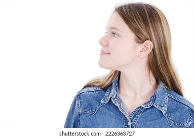 Smiling teenage girl looking side on copy space. Closeup of happy Caucasian female teenage girl isolated on white background. Close up of a cheerful girl. Studio shot