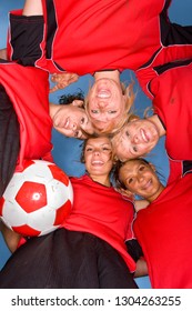 Smiling Teenage Girls In Soccer Team Uniforms In Huddle At Camera