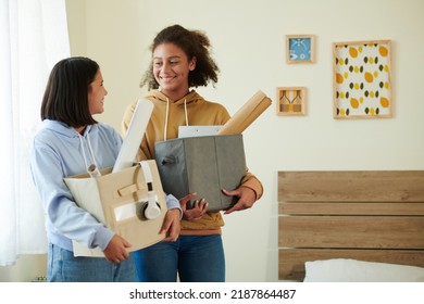Smiling teenage roommates with boxes of belongings meeting each other for the first time - Shutterstock ID 2187864487