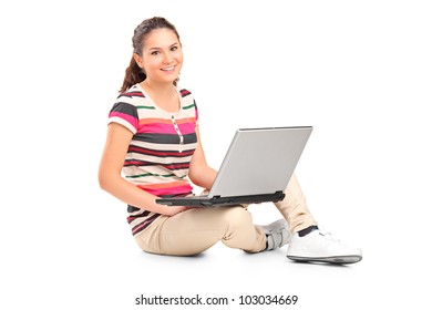 A smiling teenager doing her homework on a laptop isolated on white background