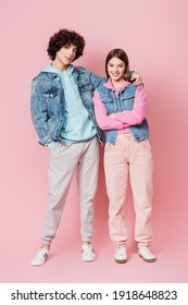 Smiling Teenager Hugging Friend And Looking At Camera On Pink Background