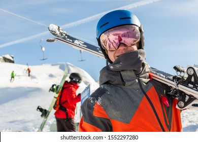 A smiling teenager shoulders his skis to hike into Backcomb Mountains glacier on a sunny winter day. - Shutterstock ID 1552297280