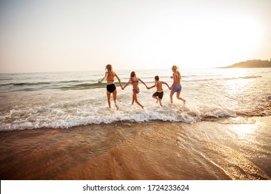 Smiling Teens Run On Vacation. Happy Young People Having Fun At Beach On Sunny Day.