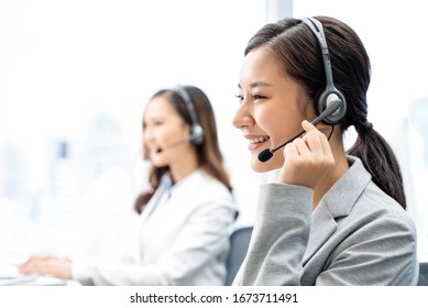 Smiling telemarketing Asian woman working in call center office - Shutterstock ID 1673711491
