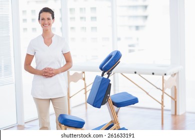 Smiling therapist smiling at camera in medical office - Powered by Shutterstock