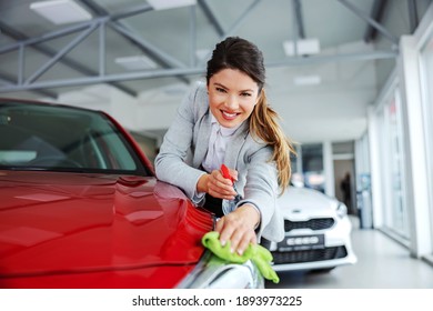 Smiling Tidy Female Car Seller Rubbing Car With Detergent And Cloth. Everything Must Be Shinny And Clean.