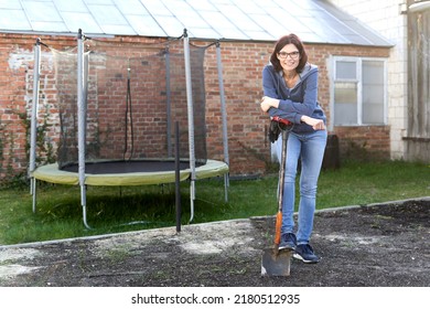 Smiling tired woman taking a break to work in the land of a vegetable garden - Powered by Shutterstock