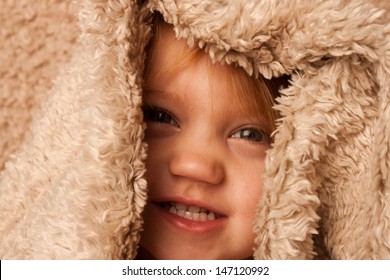 Smiling Toddler Hiding In Fur Blanket