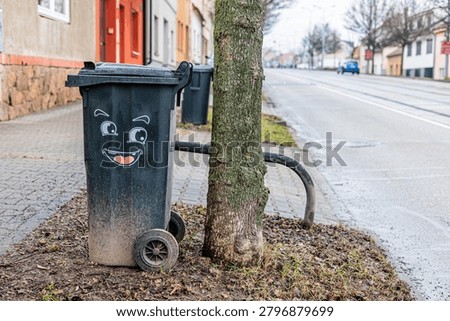 Smiling Trash Bin With Painted Face On Quiet Residential Street Near Tram Tracks