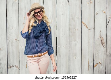 Smiling trendy model posing on wooden background