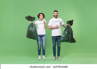 Smiling two young friends couple in volunteer t-shirt isolated on pastel green background. Voluntary free work assistance help charity grace teamwork concept. Pointing on trash bags, showing thumb up - Powered by Shutterstock