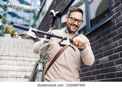 A smiling urban man going down the stairs outside with bike on his shoulder. - Shutterstock ID 2150407345