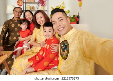 Smiling Vietnamese man taking selfie with family members at Lunar New Year celebration - Shutterstock ID 2218575273