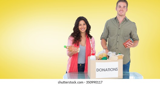 Smiling Volunteers Taking Out Food From Donations Box Against Yellow Vignette