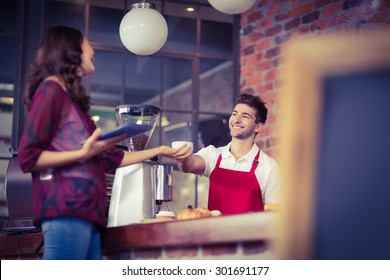 Smiling waiter serving a client at the coffee shop - Powered by Shutterstock