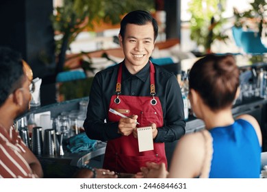 Smiling waiter talking to couple, recommending drinks and dishes of the day - Powered by Shutterstock