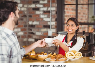 Smiling waitress serving a client at the coffee shop - Powered by Shutterstock