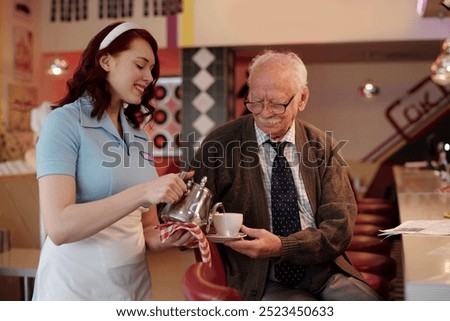 Smiling waitress serving coffee to elderly man seated at retro diner counter. Interaction between young waitress and elderly customer creating warm, nostalgic atmosphere