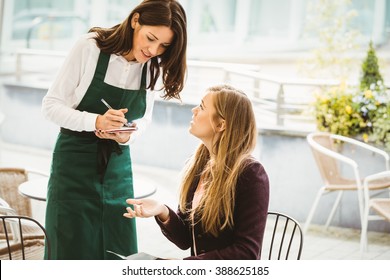 Smiling waitress taking an order in cafe
