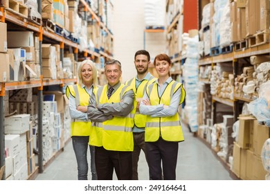 Smiling Warehouse Team With Arms Crossed In A Large Warehouse