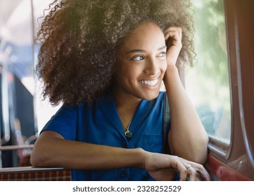 Smiling woman with afro riding bus looking out window - Powered by Shutterstock