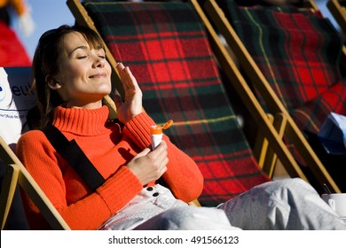Smiling Woman With Application Of Sunscreen On A Deckchair
