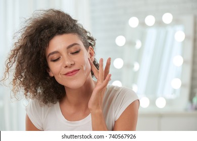 Smiling Woman Applying Serum On Her Face