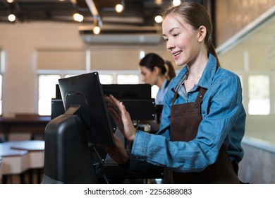 Smiling woman barista take order from customer in coffee shop. Female barista using computer desktop take order. Coffee owner concept - Powered by Shutterstock