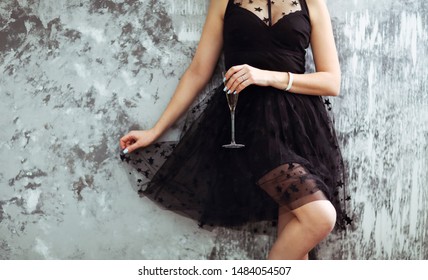 Smiling Woman In Black Dress With A Glass Of Champagne. Close Up. Party Concept