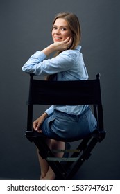 Smiling Woman Boss Sitting Back On Black Movies Director Chair Turns Away To Side. Isolated Female Profile Portrait.