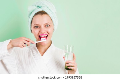 Smiling Woman brushing teeth with Toothpaste and toothbrush in bathroom. Dental higiene. Ceaning teeth.
