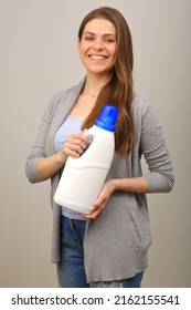 Smiling Woman In Casual Clothes Holding Laundry Detergent In White Bottle. Isolated Girl Portrait.