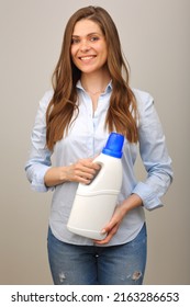 Smiling Woman In Casual Clothes Holding Laundry Detergent In White Bottle. Isolated Girl Portrait.