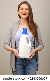 Smiling Woman In Casual Clothes Holding Laundry Detergent In White Bottle. Isolated Girl Portrait.