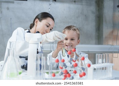 Smiling woman and child boy in lab coats working with molecular model, Science kids modern technology education concept,  - Powered by Shutterstock