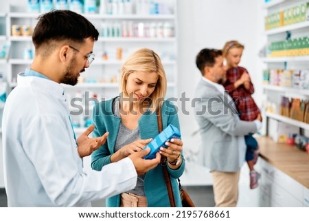 Smiling woman choosing product with help of pharmacist in a pharmacy. 
