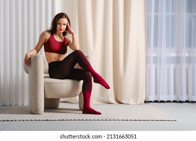 Smiling woman in colorful gradient pantyhose sitting in chair and crossed legs