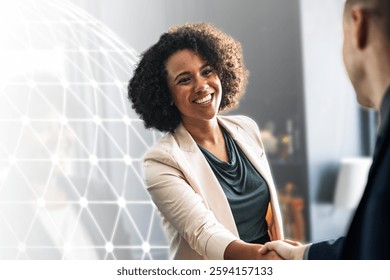 Smiling woman with curly hair in a professional setting, shaking hands. Business attire, warm interaction, positive atmosphere, professional engagement. Business meeting image.