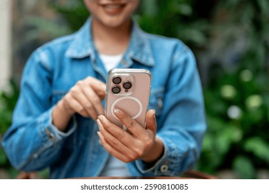 The smiling woman in denim jacket holding a smartphone with left hand and pointing at the screen with right hand. - Powered by Shutterstock - Get 15% off with code: PIKWIZARD15
