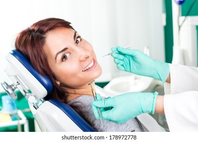 Smiling Woman At Dentist Sitting In Dentist Chair Ready For A Dental Check-up.