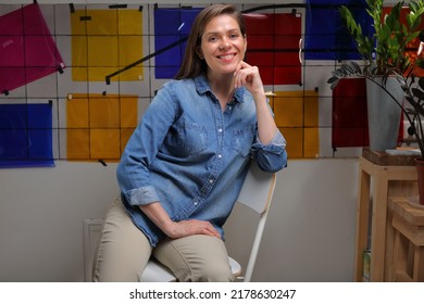 Smiling Woman Designer Student In Classroom With Color Palette Sitting On Chair.