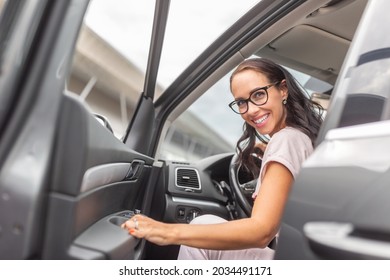 Smiling Woman Driver In Glasses Opens The Car Door Looking Backwards.