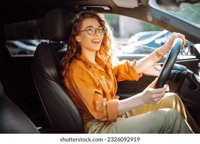 Smiling woman driving a car. Young traveler driving. Car travel, lifestyle concept. - Shutterstock ID 2326092919